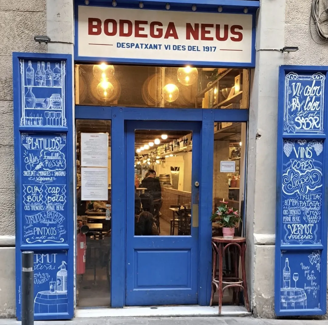 La façana blava de la Bodega Neus, amb el rètol «Despatxant vi des del 1917»